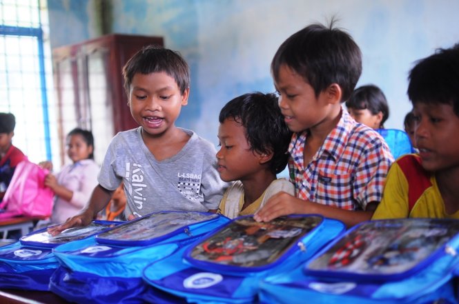 Học sinh thích thú trước những chiếc cặp mới toanh vừa được đoàn thiện nguyện trao tặng - Ảnh: LÂM THIÊN