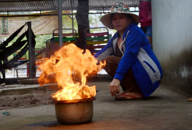 Lửa bốc cháy ngùn ngụt trong chậu nước mà bà Chi múc lên từ giếng nhà mình - Ảnh: ĐỨC TRONG