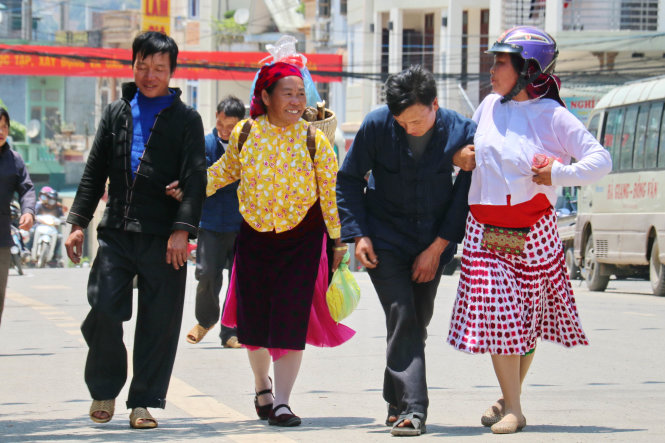 Hai người vợ dìu hai ông chồng say khướt trở về nhà từ chợ phiên Đồng Văn - Ảnh: NGỌC HIỂN