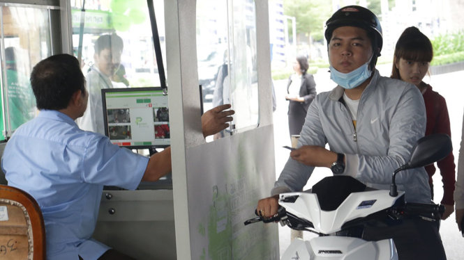 Người dân gửi xe tại bãi giữ xe máy cho khách đi xe buýt tại trung tâm thương mại Becamex trên quốc lộ 13 - Ảnh: B.SƠN