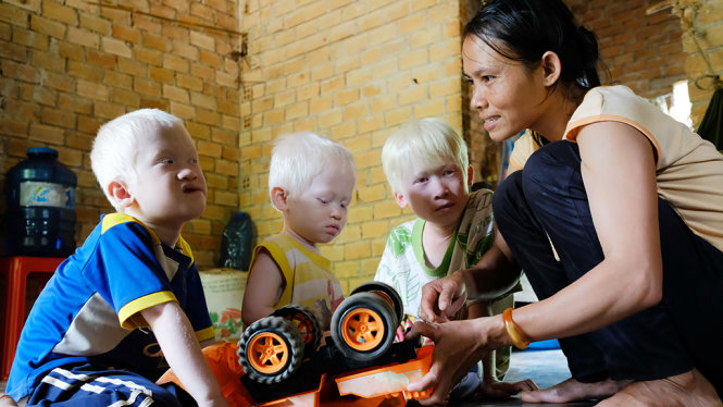 Chị K’Riểm bày trò cho các con chơi trong nhà để tránh ánh nắng - Ảnh: M.VINH