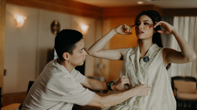 Nhà thiết kế Adrian Anh Tuấn chỉnh lại một thiết kế trong bộ sưu tập sẽ ra mắt ngày 18-6 tới cho hoa hậu Phạm Hương - Ảnh: NVCC