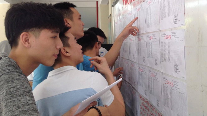 Các thí sinh xem thông tin phòng thi tại trung tâm giáo dục thường xuyên Tân Bình chiều 21-6 - Ảnh: KIM THỦY