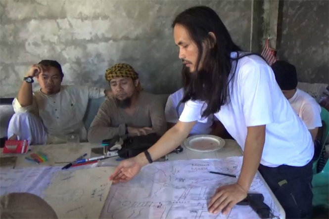 Abdullah Maute đang chỉ vào một vị trí trên bản đồ Marawi. Ngồi cạnh y là Isnilon Hapilon, kẻ cầm đầu nhóm khủng bố Abu Sayyaf. Quân đội Philippines công bố bức ảnh trên ngày 15-6 - Ảnh: AFP