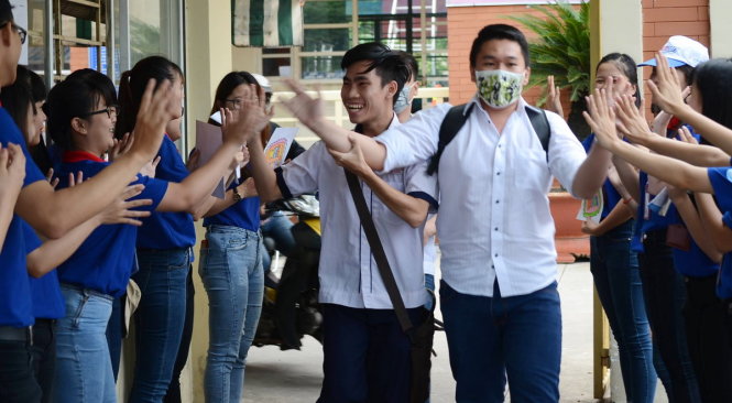 Thí sinh chia sẻ niềm vui với các tình nguyện viên tại điểm thi trường THCS Lê Văn Tám, Q. Bình Thạnh sau khi kết thúc hai môn thi lịch sử và địa lý - Ảnh: Ngọc Biển