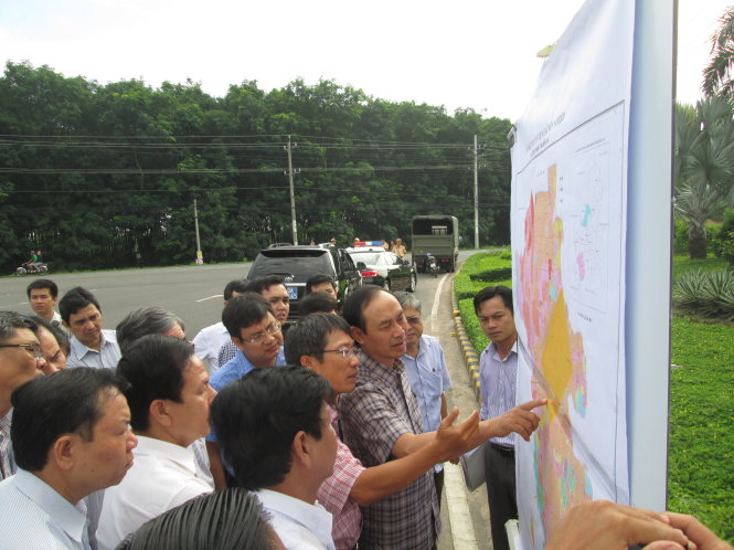 Ông Lê Đình Thọ, thứ trưởng Bộ GTVT (áo carô đậm, đang chỉ tay), nghe thuyết minh về phương án tái định cư cho dân ở vùng dự án sân bay Long Thành - Ảnh: Hà Mi