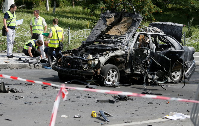 Cảnh sát điều tra Kiev tại hiện trường chiếc xe đã cháy đen của đại tá Maxim Shapoval - Ảnh: Reuters