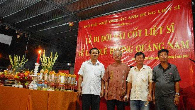 Các đồng đội cũ trong Ban liên lạc cựu chiến binh trung đoàn 96 và Chi hội 5 Nghĩa tình đồng đội sư đoàn 309 chụp ảnh kỷ niệm bên 64 hài cốt liệt sĩ - Ảnh: UYÊN TRINH