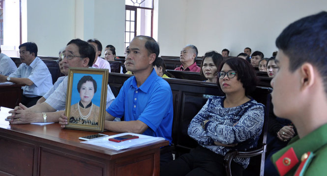 Người nhà bị hại cùng di ảnh bị hại tại tòa sáng 14-7 - Ảnh: ĐÔNG HÀ