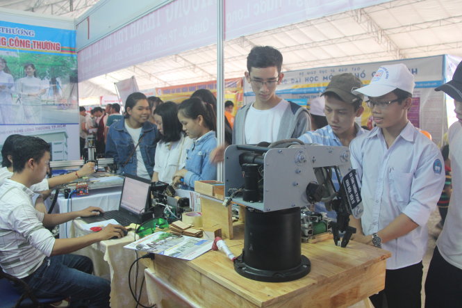 Các thí sinh thích thú với mô hình robot tại gian hàng tư vấn xét tuyển của Trường CĐ Công thương TP.HCM - Ảnh: THÁI THỊNH