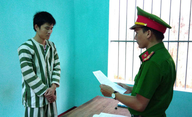 Công an tống đạt quyết định khởi tố bị can, lệnh bắt tạm giam để điều tra đối với Dương Ngọc Long - Ảnh: TẤN TÀI