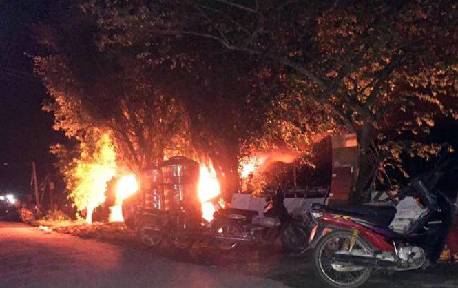 Chiếc xe ô tô bị người dân châm lửa đốt cháy bùng bùng trong đêm 20-7 - Ảnh: TRỊNH KHƯƠNG