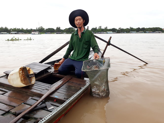 Người dân đánh bắt cá ở sông Hậu khi mùa nước lũ tràn về -  Ảnh: BỬU ĐẤU