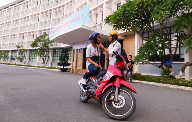 Một “bác tài” trong nhóm Huebike hỗ trợ khách đội mũ bảo hiểm trước khi khởi hành - Ảnh: V.S.