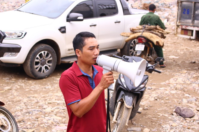 Trưởng bản Cà Văn Biên cùng chiếc loa đã cảnh báo cứu người trong đêm lũ, nay được sử dụng thông báo cho người dân đến nhận hàng cứu trợ -
 Ảnh: HÀ THANH