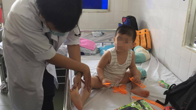 Bác sĩ đang khám cho một bệnh nhân mắc bệnh tay chân miệng nằm điều trị tại Khoa Nhiễm - thần kinh Bệnh viện Nhi Đồng 1 - Ảnh: T.DƯƠNG