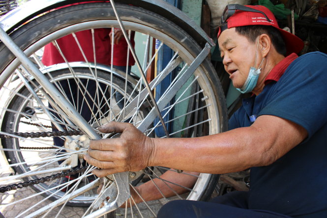 Chú Sáu Phát lắp ráp xích lô - Ảnh: N.TIÊN
