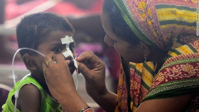 Một bà mẹ chăm sóc con tại khoa viêm não thuộc bệnh viện BDR ngày 14-8 - Ảnh: AFP