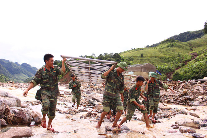 Một tấm sắt thép nặng phải đến 4 người khiêng - Ảnh: HÀ THANH