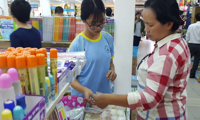 Phụ huynh và học sinh chọn mua dụng cụ học tập cho năm học mới tại nhà sách - Ảnh: NHƯ HÙNG