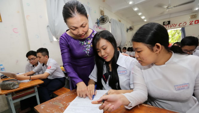 Cô Nguyễn Thị Hồng Thắm, giáo viên chủ nhiệm lớp 12D1 Trường THPT Gia Định TP.HCM, hướng dẫn học sinh làm hồ sơ đăng ký dự THPT quốc gia năm 2016 - Ảnh: NHƯ HÙNG