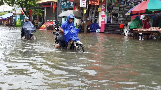 Người dân chật vật di chuyển trên phố An Đà trong trưa 30-8 - Ảnh: TIẾN THẮNG