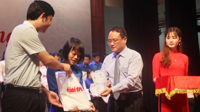Ông Nguyễn Hoàng Nguyên, ủy viên Ban biên tập báo Tuổi Trẻ và ông Lê Văn Trung, Bí thư Tỉnh đoàn Thanh Hóa trao học bổng cho các bạn tân sinh viên - Ảnh: DOÃN HÒA