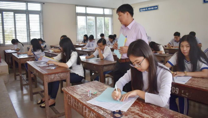 Thí sinh tại điểm thi Trường THPT Long Xuyên, An Giang trước giờ làm bài thi. Tại Cụm thi An Giang năm nay có 14.112 thí sinh dự thi. Trước 'giờ G', nhiều thí sinh vẫn tranh thủ ôn bài với nhiều ưu tư, lo lắng - Ảnh: BỨU ĐẤU