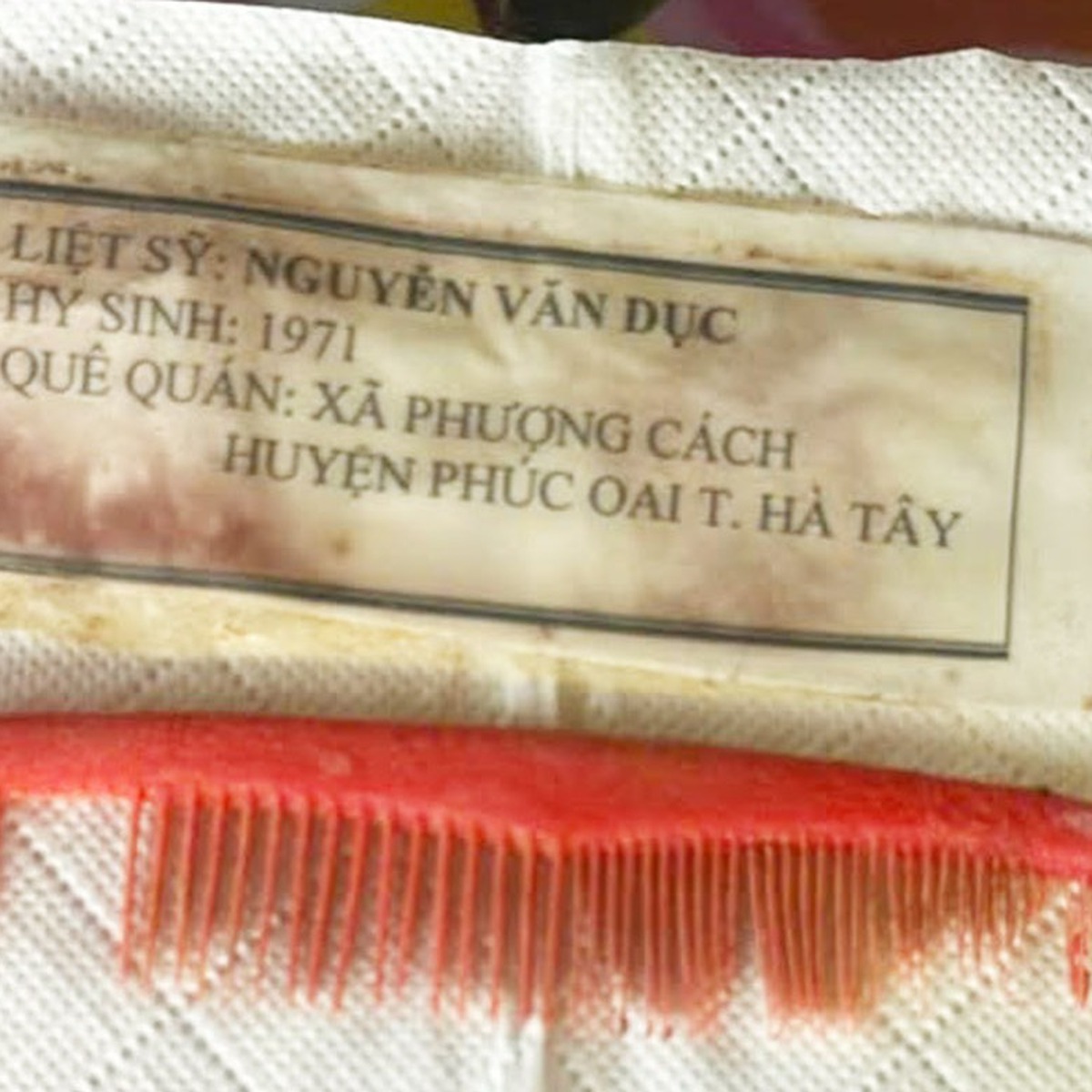 Chiếc lược đỏ, tấm giấy in dòng chữ liệt sĩ Nguyễn Văn Dục, quê Hà Tây