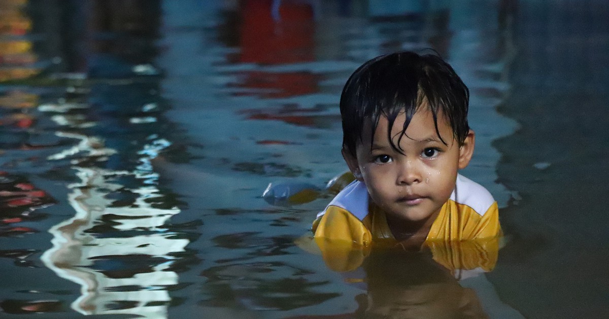 Người dân đắp ‘đê’ trước cửa nhà, trẻ em bơi giữa dòng triều cường đạt đỉnh tại TP.HCM