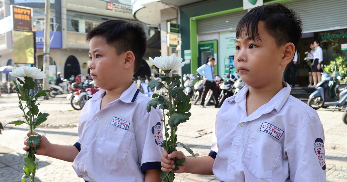 Người dân cầm hoa trắng đợi tiễn đưa các anh