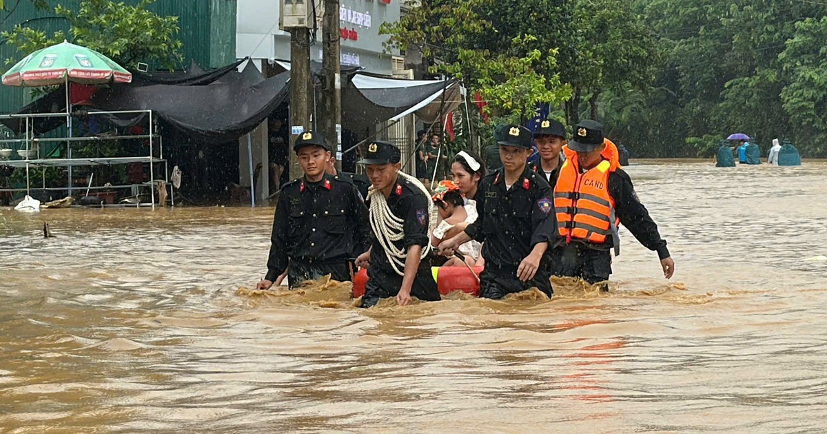 Cảnh sát ngâm mình trong nước sâu đưa người dân ra khỏi vùng ngập ở Lào Cai