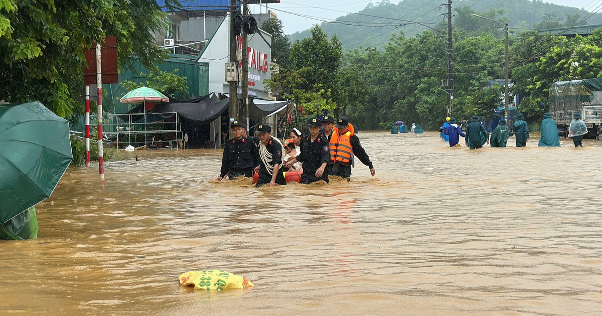 Cảnh sát ngâm mình trong nước sâu đưa người dân ra khỏi vùng ngập ở Lào Cai