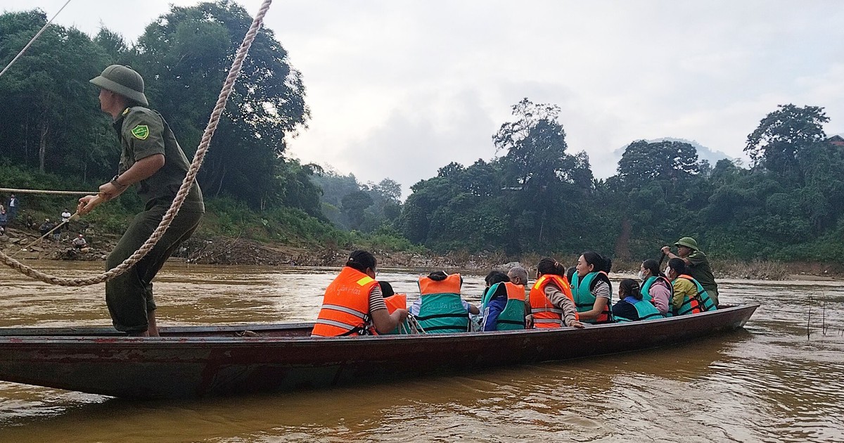 Soldiers use boats to carry students across a river for the first day of school