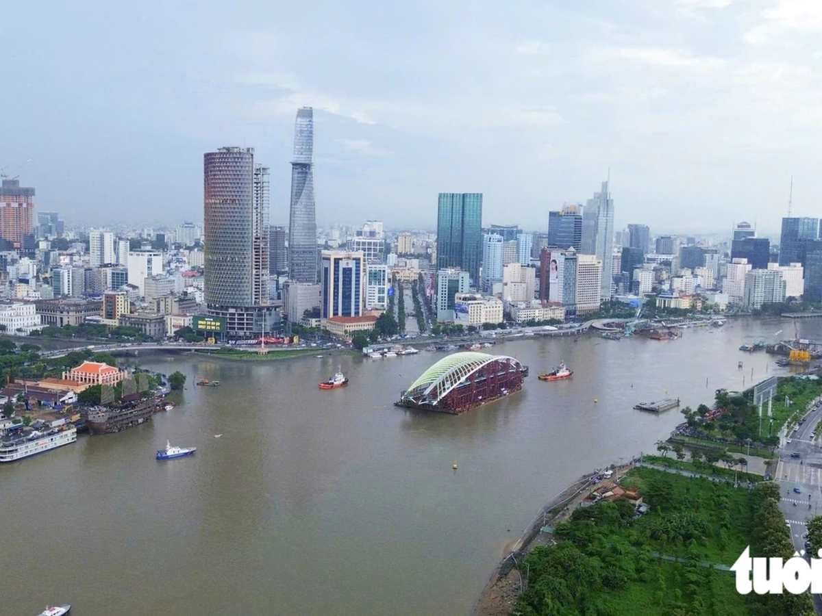 Barge carrying 3,400-tonne pedestrian bridge arch arrives in downtown Ho Chi Minh City