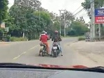 Hai người phụ nữ hồn nhiên dừng xe máy giữa đường buôn chuyện