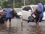 Người đàn ông bê xe máy điện qua đường ngập vì sợ chết máy