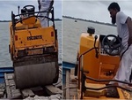 Màn lái xe lu xuống thuyền đi vào lòng sông