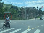 Người đàn ông dừng xe máy chờ đèn đỏ kiểu ngược đời
