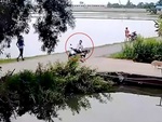 Hai thanh niên chạy xe máy, ôm cua vào lòng ao