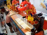Chủ tiệm vàng tươi cười lấy tiền cho đội lân vào nhà