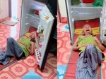 Cụ bà mở cửa tủ lạnh, kê đầu vào nằm để tránh nóng