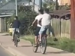 Bé trai ngồi sau xe đạp nẩy như lò xo