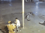 Hai người đàn ông ngồi nhậu ở vỉa hè bị gió quật ngã