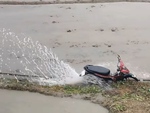 Bác nông dân dùng xe máy tát nước lên ruộng cày