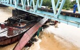 Cụm sà lan bị lũ cuốn trôi mắc kẹt ở trụ cầu Mỹ Chánh trên tuyến đường sắt Bắc Nam