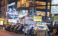 Eateries take over sidewalks along Ho Chi Minh City street, forcing pedestrians onto road