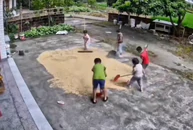 Các em nhỏ giúp nhau dọn lúa chạy mưa khi người lớn vắng nhà