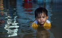 Người dân đắp ‘đê’ trước cửa nhà, trẻ em bơi giữa dòng triều cường đạt đỉnh tại TP.HCM