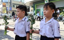 Người dân cầm hoa trắng đợi tiễn đưa các anh
